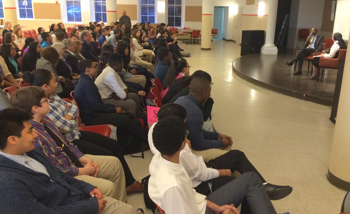 An audience of Cristo Rey sophomores and staff and Project Redwood partners listen to Deo speak about his life experiences